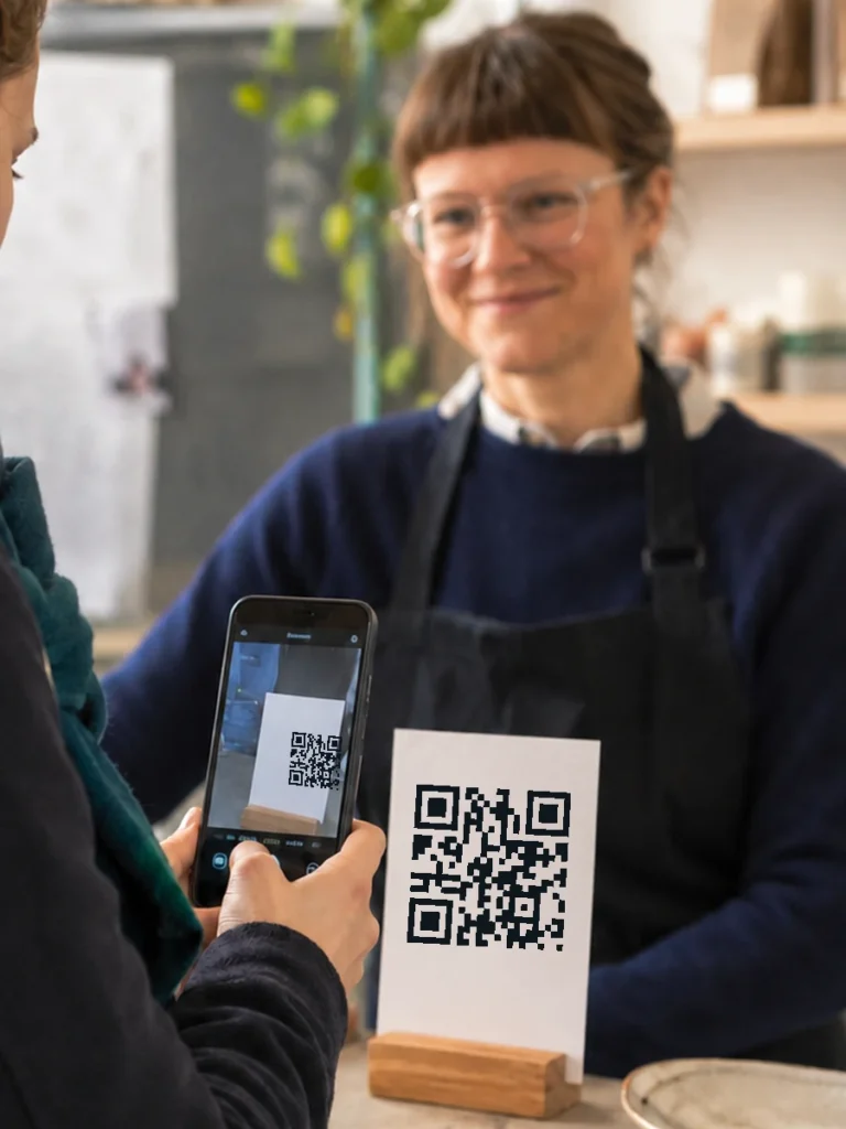 Kundin scannt einen QR-Code für eine Bewertung
